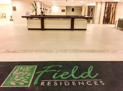 a man sitting at a desk in a lobby at Entire unit with balcony at SMDC Field Residences, behind Sucat near NAIA in Manila