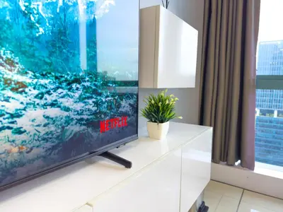 a tv on a white dresser in a room with a window at 1BR BGC, One Uptown Residence B001 in Manila