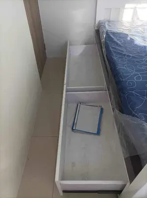 a book sitting on the floor next to a bed at Chill in Peace Staycation 2BR condo at Field Residences, Sucat near NAIA in Manila