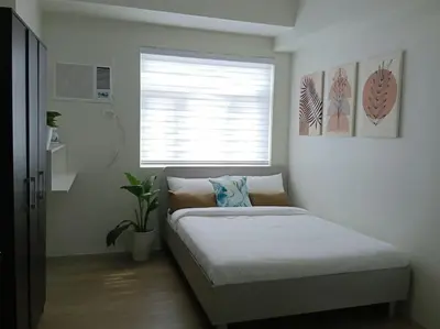 a bed in a room with a window and a bed sidx sidx sidx at Vista GL Taft Studio Unit in Manila