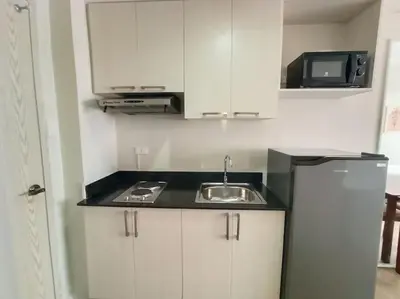 a small kitchen with a sink and a microwave at Vista GL Taft Studio Unit in Manila