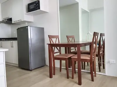 a kitchen with a table and chairs and a refrigerator at Vista GL Taft Studio Unit in Manila