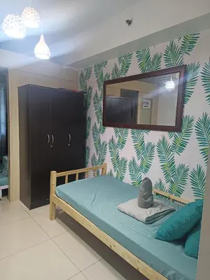 a bedroom with a bed with a mirror on the wall at SEA RESIDENCES NEAR MALL OF ASIA BY Amigo's place in Manila
