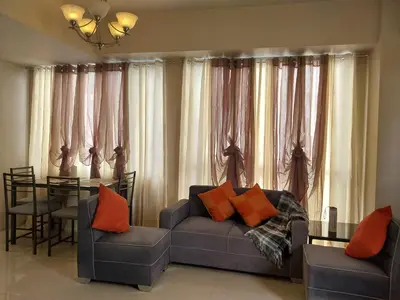 a living room with a couch and a table at Emy Cozy Studio unit with street view balcony in Manila