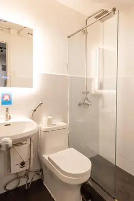 a bathroom with a toilet and a sink and a shower at Homey and Cozey Poblacion Makati S03 in Manila