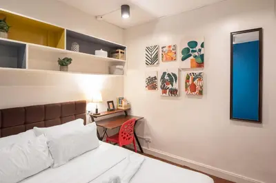 a bedroom with a bed and a desk and a mirror at Homey and Cozey Poblacion Makati S05 in Manila