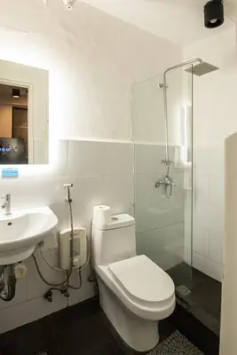 a bathroom with a toilet and a sink and a shower at Homey and Cozey Poblacion Makati S05 in Manila