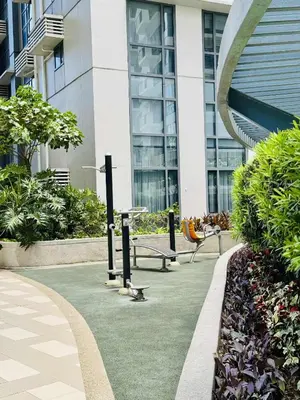 a building with a park with benches in front of it at Luxurious Viceroy Residence Walk to Venice Grand Canal in Manila