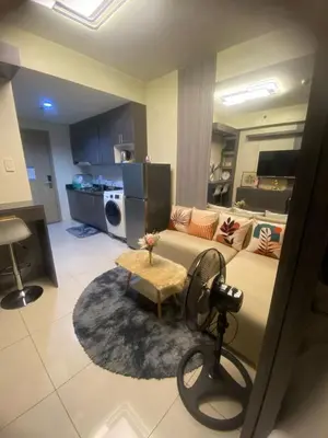 a large living room with a couch and a kitchen at Cozy Urban Apartment in Pasay City in Manila