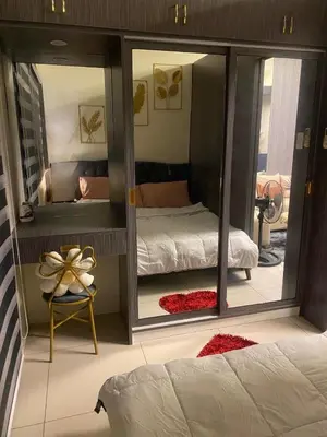 a bedroom with a bed and a large mirror at Cozy Urban Apartment in Pasay City in Manila