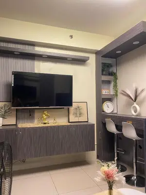 a living room with a flat screen tv on a wall at Cozy Urban Apartment in Pasay City in Manila