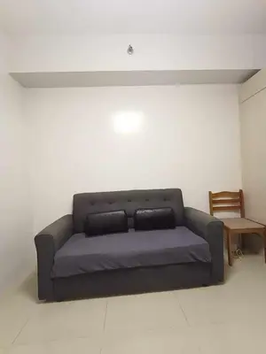 a living room with a couch and a chair at Sea Residences Staycation MOA Pasay in Manila