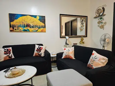 a living room with two black couches and a table at Marty's Turf at San Lorenzo in Manila