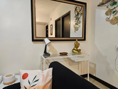 a mirror on a wall above a table with a lamp at Marty's Turf at San Lorenzo in Manila