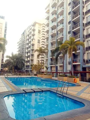 a swimming pool in front of a large apartment building at One Palm Tree Condominium in Manila