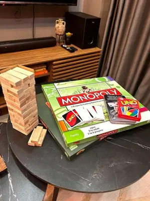 a table with a book and a stack of wooden games at Kapitolyo Prisma Residential Condo TCPH21 - NYC Vibes Penthouse with KTV Pool and Balcony with City View Panorama 5 Min Drive to BGC St Lukes and Ortigas - Staycations by SMS in Manila