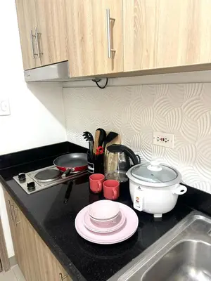 a kitchen counter top with a sink and a stove at Cozy Korean Studio Shore 2 Residences in Manila