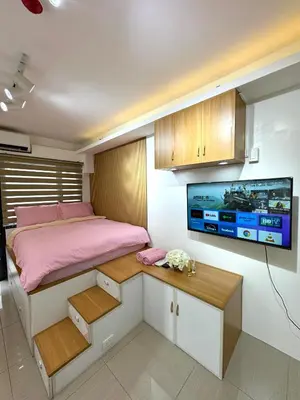 a bedroom with a bed and a tv on the wall at Cozy Korean Studio Shore 2 Residences in Manila