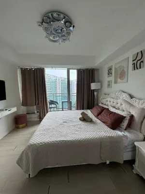 a bedroom with a large bed and a chandelier at Royale One Five Azure Staycation in Manila