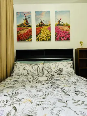 a bedroom with four paintings of flowers and windmills at LD Cozy Condo - Grace Residences, Taguig City near BGC in Manila