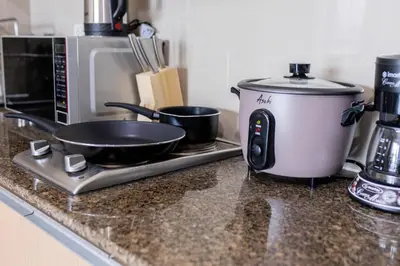 a slow cooker on a counter next to a microwave at LUXX BGC Venice in Manila