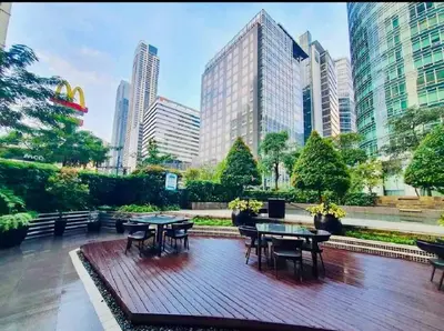 a wooden deck with tables and chairs in a city at Avant at the Fort BGC 1BR Flr to Ceiling Cor Unit with Great View in Manila