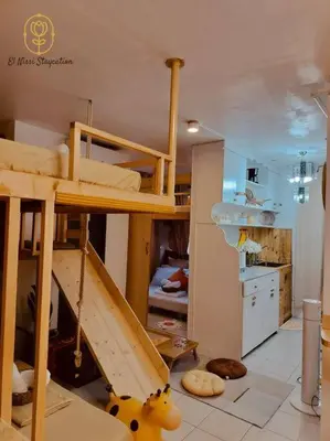 a room with a bunk bed and a kitchen at El Nissi Staycation, The Play Cabin, Beside Enchanted Kingdom in Santa Rosa