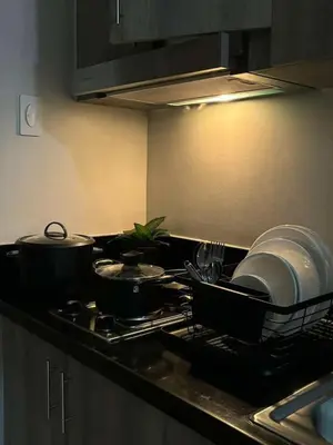 a kitchen with pots and pans on a stove at Cozy Condo Stay Near MOA in Manila