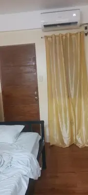 a bedroom with a bed and a window with a television at Bahay ni Ate Rose in Manila