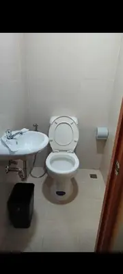 a bathroom with a white toilet and a sink at Bahay ni Ate Rose in Manila