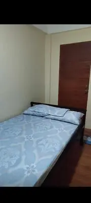 a bedroom with a bed with a wooden head board at Bahay ni Ate Rose in Manila