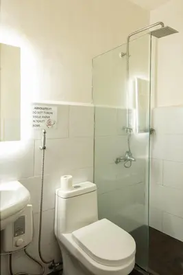 a bathroom with a toilet and a glass shower at Homey and Cozey Poblacion Makati S11 in Manila