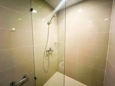 a bathroom with a glass shower with a toilet at Luxury BGC Condo Across Mitsukoshi #upt112b in Manila