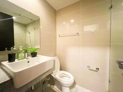 a bathroom with a sink and a toilet and a mirror at Luxury BGC Condo Across Mitsukoshi #upt112b in Manila