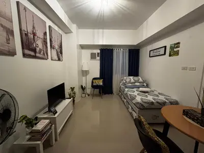 a bedroom with a bed and a tv in it at Calicon Suites in Manila