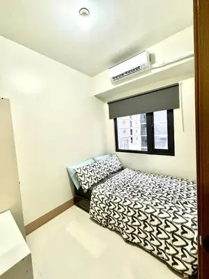 a small room with two beds and a window at Casa Liandro in SMDC shore 3 in Manila