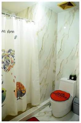 a bathroom with a white shower curtain and a toilet at Brianna's haven property rental in Manila