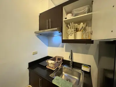 a kitchen with a sink and a counter top at Your perfect retreat in Stamford! Enjoy our stylish, fully furnished studio just steps away from the vibrant Venice Mall in Manila