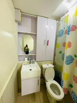 a bathroom with a toilet and a sink and a mirror at DJ Apartment in Manila
