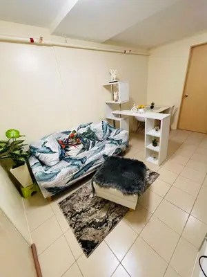 a room with a bed and a table and a desk at DJ Apartment in Manila