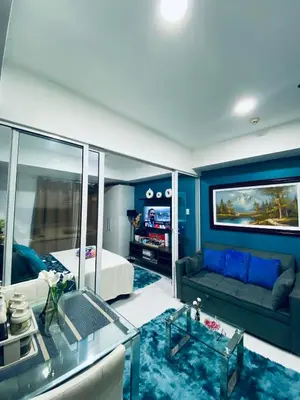 a living room with a bed and a couch at Cozy Inn Azure in Manila