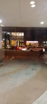 a parking lot with cars in a building at night at Sea Residences MOA by -MJ in Manila