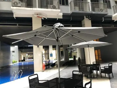 a table and chairs with an umbrella in front of a building at Natalie's Place in Mall of Asia Complex in Manila