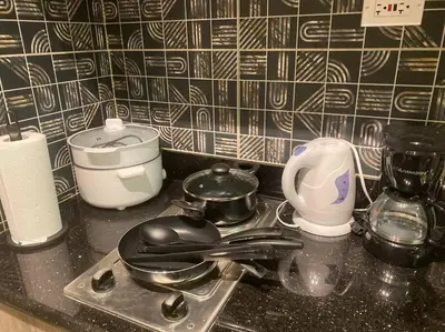 a kitchen counter with pots and pans on a stove at 1BR CONDO Fame Residences Mandaluyong- Be My Guest Staycation- Near SM Megamall, Greenfield District, & Ortigas in Manila