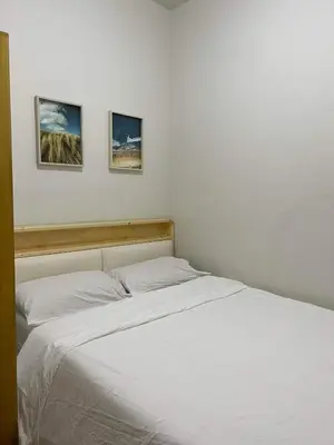 a bed in a bedroom with two pictures on the wall at Twin Duckworth Suites T1 in Manila