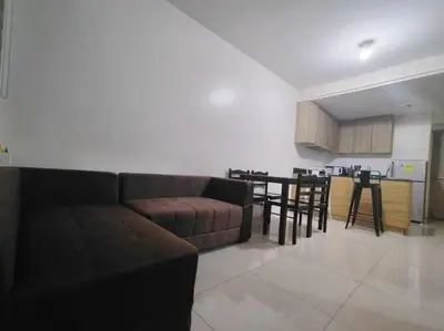 a living room with a couch and a table and a kitchen at Spacious 2-BR Condo - Shore Residence Tower D - Walking distance to Moa in Manila