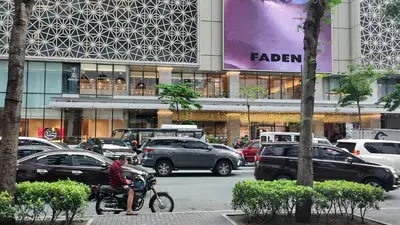 a man riding a bike in front of a building at Cozy 1 bedroom condo in Uptown BGC in Manila