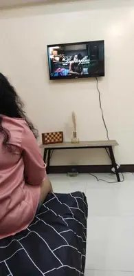 a person sitting on the floor in front of a tv at The Viceroy Tower1 condominium in Manila