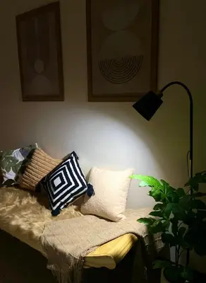 a room with a couch with pillows and a lamp at Luxury Bauhaus inspired apartment near Makati in Manila