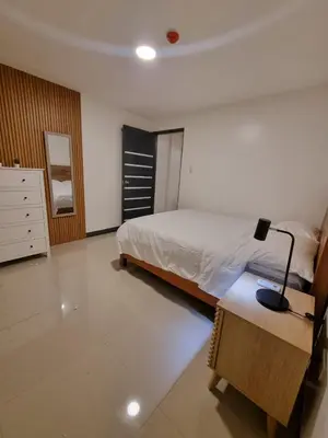 a bedroom with a bed and a desk with a lamp at Flat 35, Unit 2A in Manila
